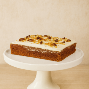 Classic carrot cake topped with smooth cream cheese frosting and walnut pieces